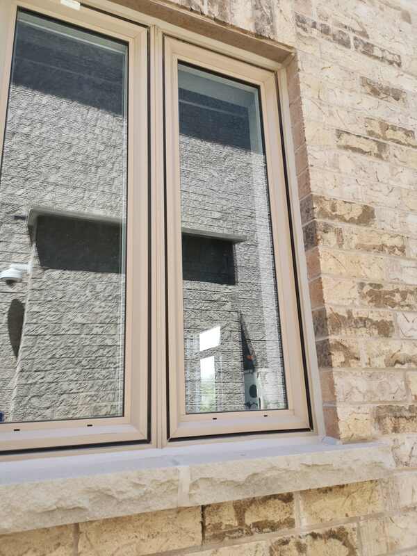 Close-up of a flawlessly finished, professionally tooled waterproof sealant bead around a tan window frame by Proper Caulking in Burlington.
