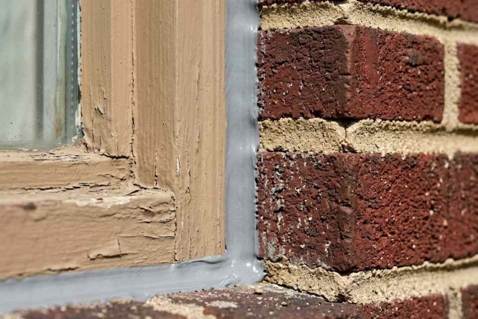 Close-up of a flawlessly finished, professionally tooled waterproof sealant bead around a window frame by Proper Caulking in Burlington.
