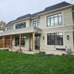 Premium black window frames and exterior stucco moldings prepped with professional paintable caulking on a luxury home in Burlington Ontario.