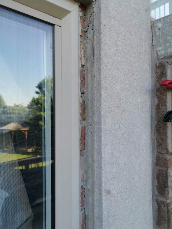 Close-up of an unsealed window frame and exposed exterior brick gap before a residential sealing service by Proper Caulking in Burlington.