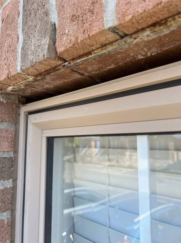 Close-up view of an empty window lintel joint completely cleared of old caulking down to the clean substrate before installing a backer rod.